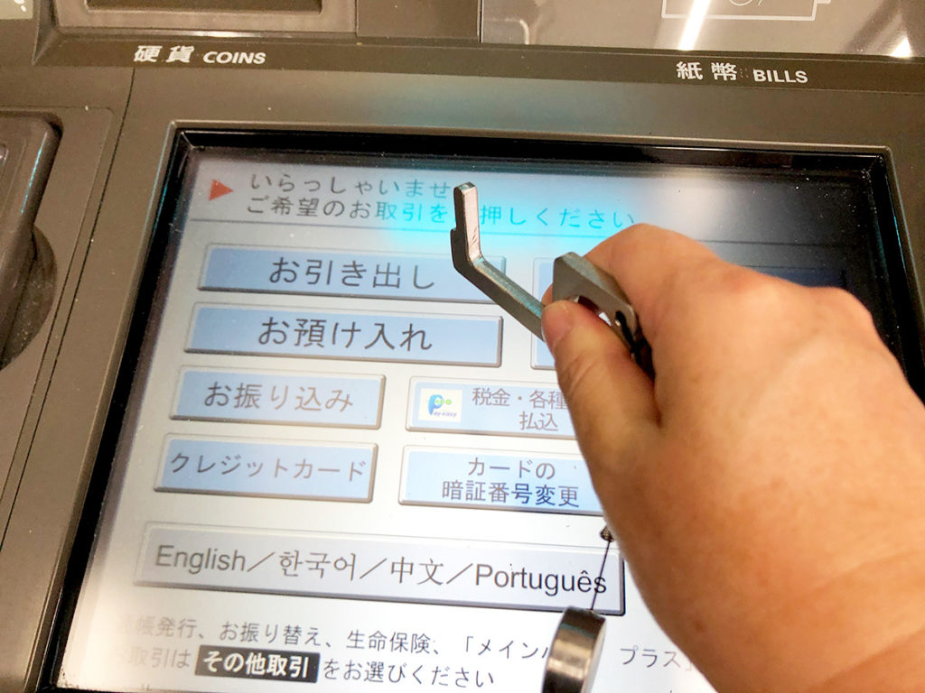 銀行のATMをドアオープナーで操作